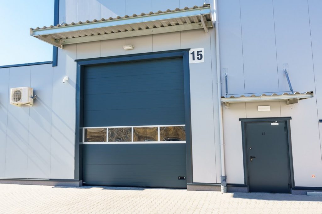 Porte de garage sectionnelle industrielle avec hublots - style moderne loft