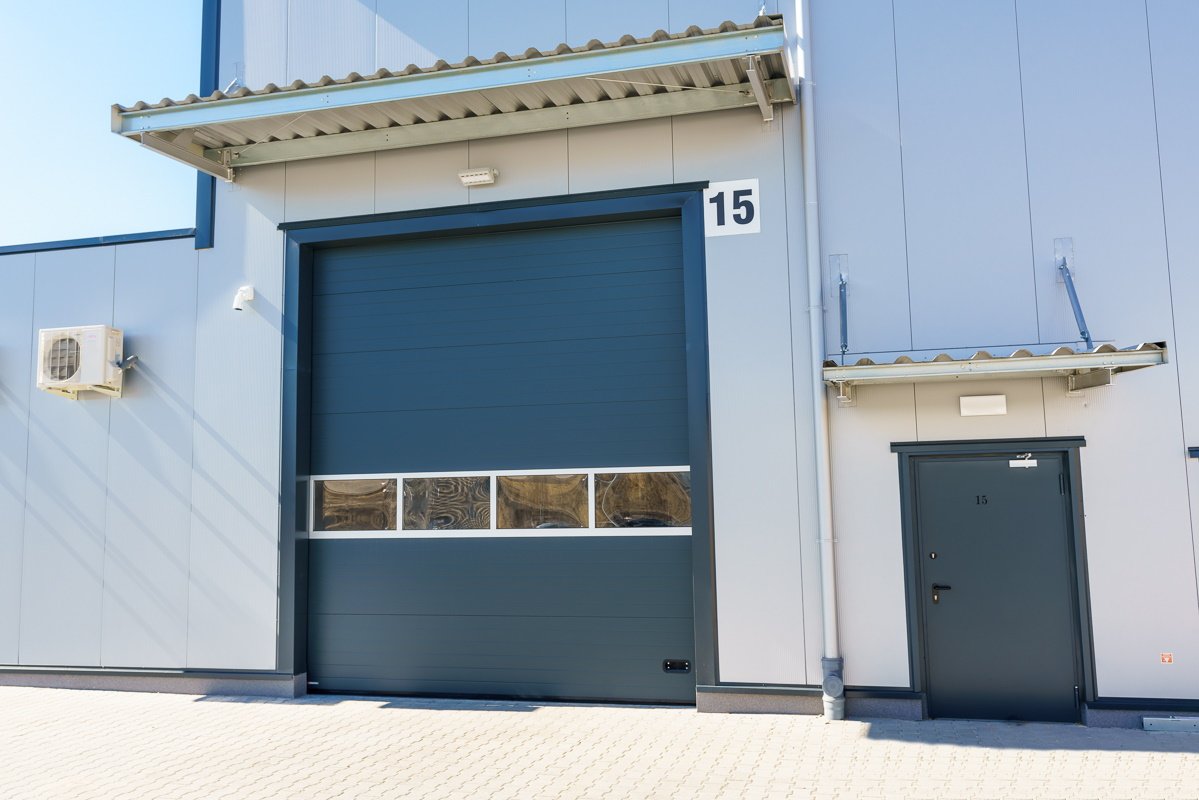 Porte garage sectionnelle industrielle hublots moderne