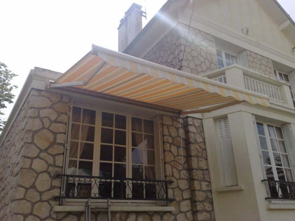 Store banne balcon rayures orange maison pierre pose sur mesure