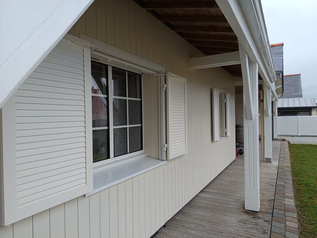Volets battants blancs sur maison ossature bois