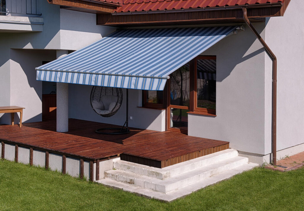 Store banne sans coffre rayures bleues terrasse bois maison